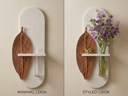 Wooden leaf wall art with glass vase above a modern console table