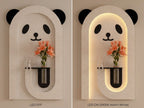 A panda-shaped wall sconce shown in two side-by-side views: LED OFF on the left and LED ON (3000K Warm White) on the right. The sconce has a textured light beige stone-like finish with black panda ears, eyes, and nose, and a warm glowing arched backlit frame.